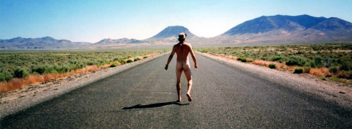 rear shot of naked guy on a desert highway